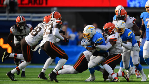 Oct 10, 2021; Inglewood, California, USA; Los Angeles Chargers running back Austin Ekeler (30) is brought down by Cleveland Browns middle linebacker Anthony Walker (4) during the second half at SoFi Stadium. Mandatory Credit: Gary A. Vasquez-USA TODAY Sports
