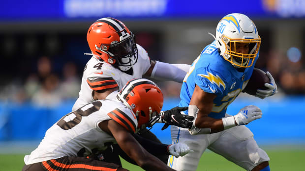 Oct 10, 2021; Inglewood, California, USA; Los Angeles Chargers running back Austin Ekeler (30) runs the ball ahead of Cleveland Browns middle linebacker Anthony Walker (4) and defensive tackle Malik McDowell (58) during the second half at SoFi Stadium. Mandatory Credit: Gary A. Vasquez-USA TODAY Sports
