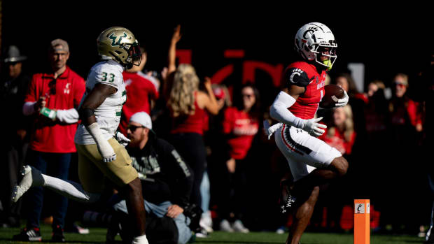 Cincinnati Bearcats wide receiver Tre Tucker (1) scores a touchdown as South Florida Bulls cornerback T-Mac Simpson (33) chases in the third quarter of the NCAA Football game between the Cincinnati Bearcats and the South Florida Bulls at Nippert Stadium in Cincinnati on Saturday, Oct. 8, 2022. South Florida Bulls At Cincinnati Bearcats 546
