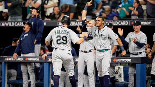 Cal Raleigh and Julio Rodríguez celebrate after Raleigh scores the Mariners’ go-ahead run in the ninth inning vs. the Blue Jays.