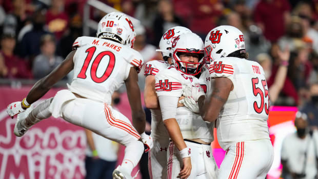 Utah Utes quarterback Cameron Rising (7) celebrates scoring a third quarter touchdown with wide receiver Money Parks (10) and offensive lineman Nick Ford (55) during the third quarter against the USC Trojans.