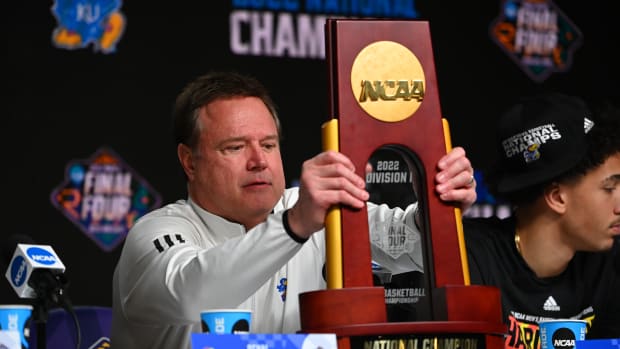 Apr 4, 2022; New Orleans, LA, USA; Kansas Jayhawks head coach Bill Self adjusts the national championship trophy during a press conference after defeating the North Carolina Tar Heels in the 2022 NCAA men's basketball tournament Final Four championship game at Caesars Superdome. Mandatory Credit: Bob Donnan-USA TODAY Sports