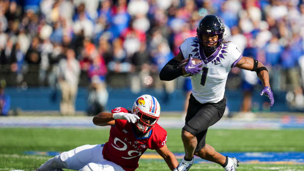 Oct 8, 2022; Lawrence, Kansas, USA; TCU Horned Frogs wide receiver Quentin Johnston (1) runs with the ball past Kansas Jayhawks defensive lineman Malcolm Lee (99) during the first half at David Booth Kansas Memorial Stadium. Mandatory Credit: Jay Biggerstaff-USA TODAY Sports