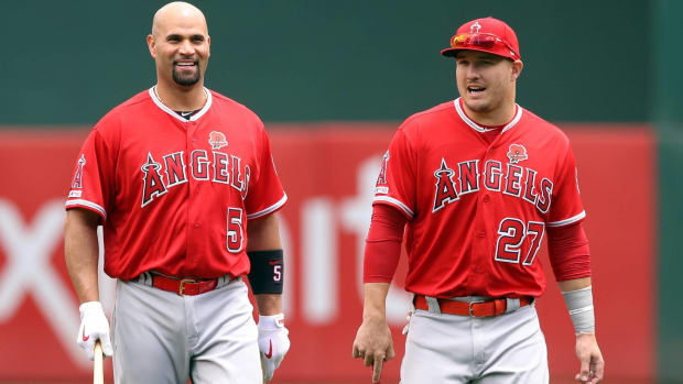 Former Angels teammates Albert Pujols and Mike Trout talk on the field before a game.