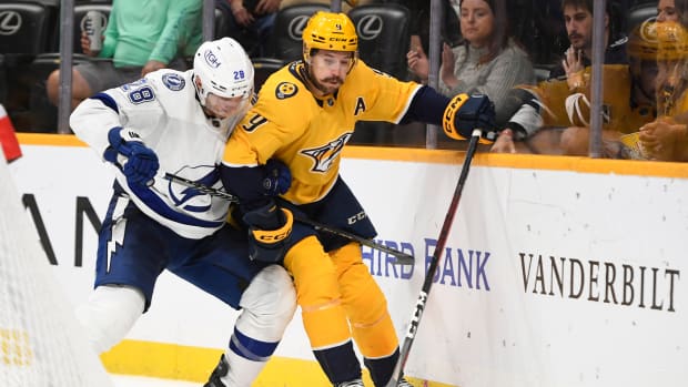 Sep 30, 2022; Nashville, Tennessee, USA; Tampa Bay Lightning defenseman Ian Cole (28) and Nashville Predators left wing Filip Forsberg (9) fight for the puck during the third period at Bridgestone Arena.