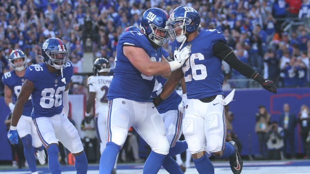 Oct 16, 2022; East Rutherford, New Jersey, USA; New York Giants running back Saquon Barkley (26) celebrates his touchdown against the Baltimore Ravens with guard Mark Glowinski (64) during the fourth quarter at MetLife Stadium.
