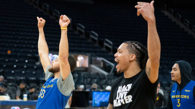 Stephen Curry and Damion Lee of the Warriors celebrate a practice basket.