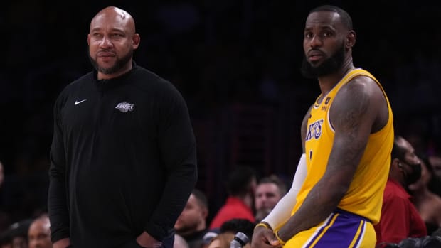 Lakers coach Darvin Ham (left) and forward LeBron James (6) sit and watch the action during a game against the Clippers.