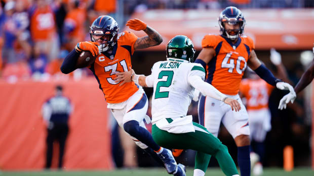 Denver Broncos free safety Justin Simmons (31) runs the ball after an interception as New York Jets quarterback Zach Wilson (2) defends in the fourth quarter at Empower Field at Mile High.