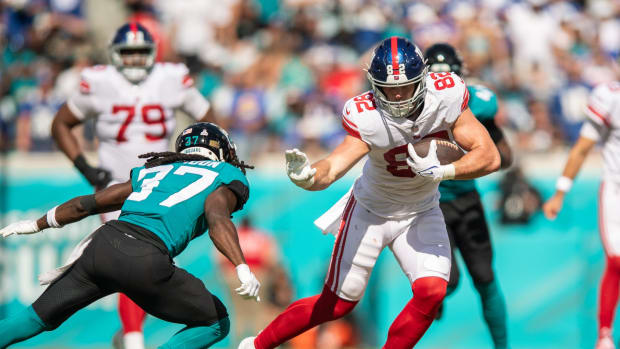 Oct 23, 2022; Jacksonville, Florida, USA; New York Giants tight end Daniel Bellinger (82) catches the ball against Jacksonville Jaguars cornerback Tre Herndon (37) in the second quarter at TIAA Bank Field.