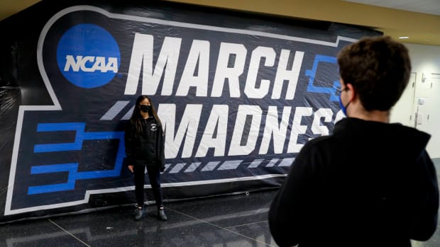 Joey powers (right) and Kathleen Martinus take pictures in front of a March Madness sign during the first round of the 2021 NCAA Tournament on Thursday, March 18, 2021, at Mackey Arena in West Lafayette, Ind.