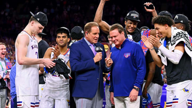 Jim Nantz presents the NCAA Championship trophy to Bill Self and Kansas after the 2022 March Madness tournament.