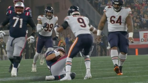 Patriots quarterback Mac Jones slides and kicks Bears defensive back Jaquan Brisker.