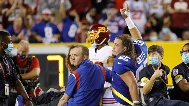Giants center Nick Gates (65) waves to fans while being carted off the field after a leg injury against the Washington Football Team in the first quarter at FedExField.