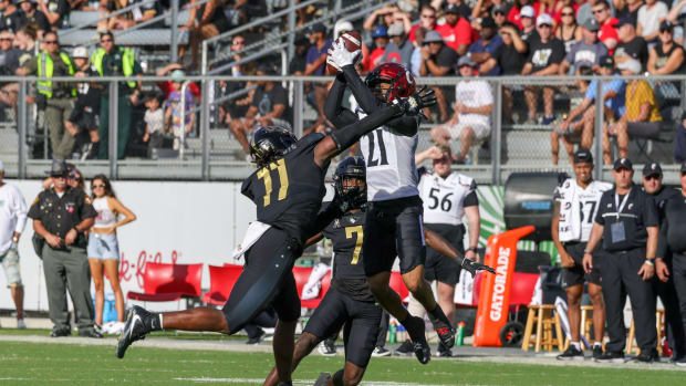 Oct 29, 2022; Orlando, Florida, USA; Cincinnati Bearcats wide receiver Tyler Scott (21) catches a pass as UCF Knights linebacker Jeremiah Jean-Baptiste (11) and cornerback Davonte Brown (7) move in during the second quarter at FBC Mortgage Stadium. Mandatory Credit: Mike Watters-USA TODAY Sports