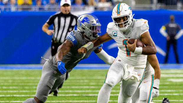 Oct 30, 2022; Detroit, Michigan, USA; Miami Dolphins quarterback Tua Tagovailoa (1) runs with the ball and tries to avoid a tackle from Detroit Lions cornerback Jeff Okudah (1) during the second half at Ford Field.