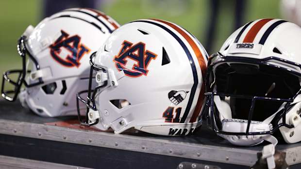 Auburn helmets sit on a crate on the sidelines during a game.