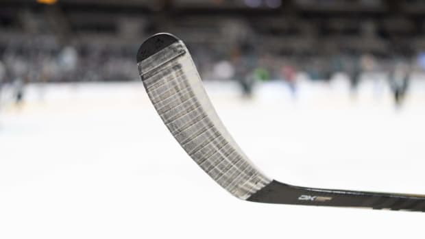 A hockey stick in the air on the ice before a game.