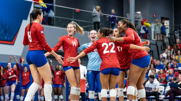 Kansas Jayhawk players celebrate a scored point in a home match against the Kansas State Wildcats.