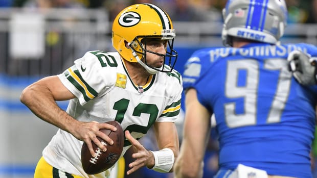Aaron Rodgers puffs his cheeks out as he looks for somewhere to put the football against the Lions.