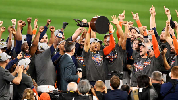 Astros shortstop Jeremy Peña holds up the World Series MVP trophy.