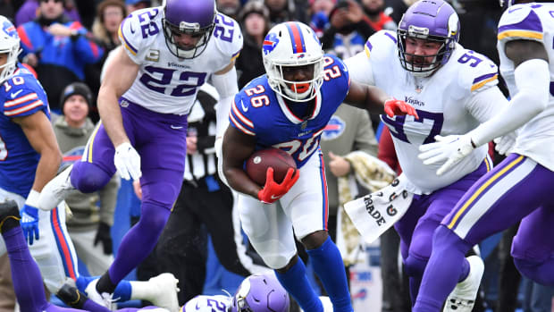 Nov 13, 2022; Orchard Park, New York, USA; Buffalo Bills running back Devin Singletary (26) runs between Minnesota Vikings safety Harrison Smith (22) and defensive tackle Jordan Phillips (97) and safety Camryn Bynum (24) in the first quarter at Highmark Stadium.