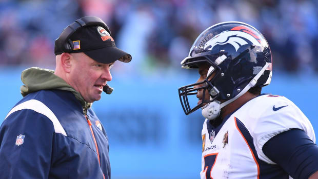 Denver Broncos head coach Nathaniel Hackett talks with quarterback Russell Wilson (3) during a timeout during the second half against the Tennessee Titans at Nissan Stadium.