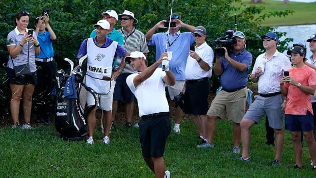 Brooks Koepka hits a shot in front of fans at the 2022 LIV Golf Team Championship.
