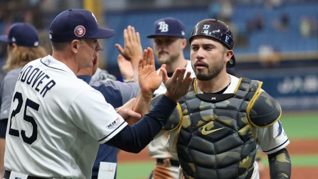 May 27, 2019; St. Petersburg, FL, USA; Tampa Bay Rays catcher Travis d'Arnaud (37) high fives major league field coordinator Paul Hoover (25) and teammates after defeating the Toronto Blue Jays at Tropicana Field. Mandatory Credit: Kim Klement-USA TODAY Sports
