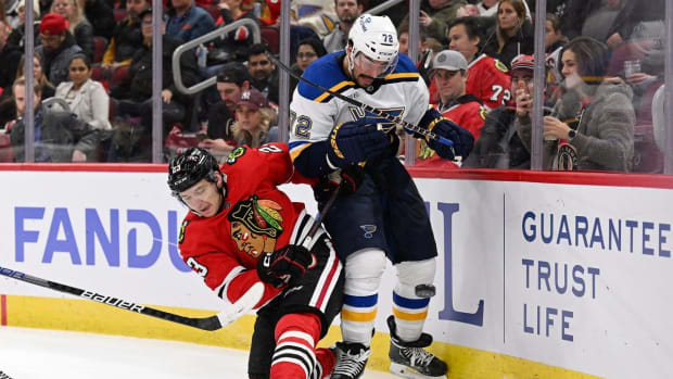 Nov 16, 2022; Chicago, Illinois, USA; Chicago Blackhawks forward Philipp Kurashev (23) battles with St. Louis Blues defenseman Justin Faulk (72) for control of the puck in the second period at the United Center. Mandatory Credit: Jamie Sabau-USA TODAY Sports