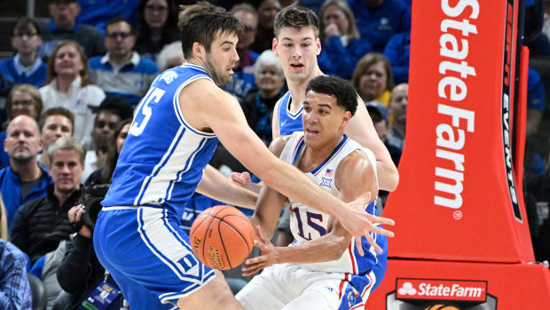 Nov 15, 2022; Indianapolis, Indiana, USA; Kansas Jayhawks guard Kevin McCullar Jr. (15) passes the ball away from Duke Blue Devils center Ryan Young (15) during the first half at Gainbridge Fieldhouse. Mandatory Credit: Marc Lebryk-USA TODAY Sports