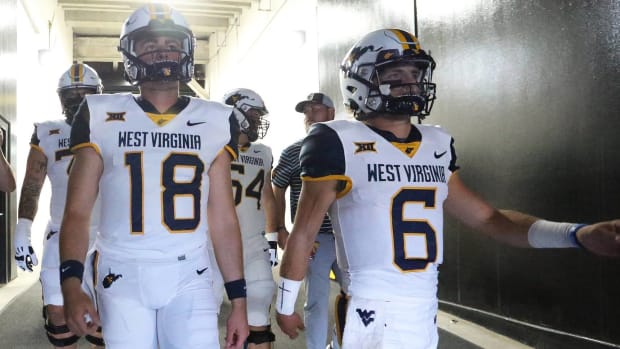 West Virginia quarterbacks JT Daniels and Garrett Greene lead the team out of the tunnel before a game vs. Pittsburgh.