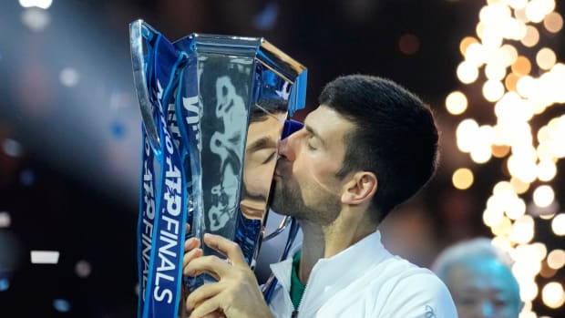 Novak Djokovic kisses the 2022 Nitto ATP Finals trophy after beating Casper Ruud.