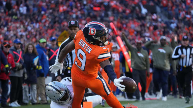 Denver Broncos wide receiver Kendall Hinton (9) reaches for the end zone as Las Vegas Raiders safety Duron Harmon (30) tackles in the first quarter at Empower Field at Mile High.