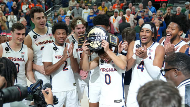 The Virginia Cavaliers celebrate after defeating the Illinois Fighting Illini 70-61 to win the Continental Tire Main Event Championship at T-Mobile Arena.