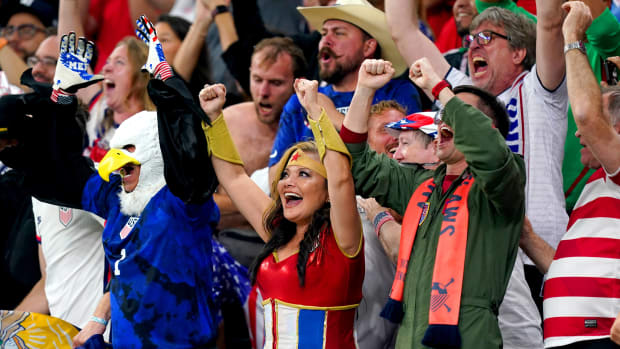 A USA fan dressed as Wonder Woman pictured celebrating in Qatar after seeing Timothy Weah score against Wales at the 2022 World Cup