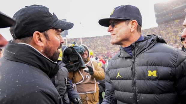 Ryan Day and Jim Harbaugh meet on the field after 2021’s game between Michigan and Ohio State.