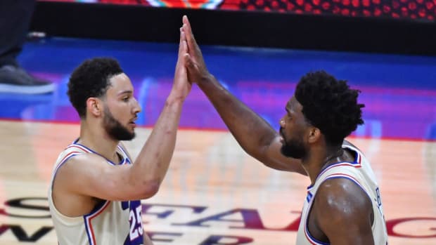Former 76ers teammates Ben Simmons and Joel Embiid high-five during a game in 2021.