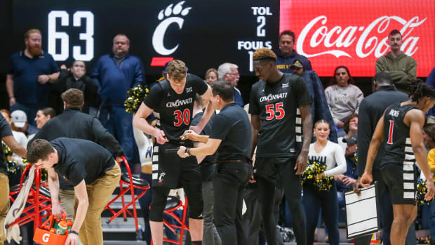 Jan 31, 2024; Morgantown, West Virginia, USA; Cincinnati Bearcats head coach Wes Miller talks with Cincinnati Bearcats forward Viktor Lakhin (30) and Cincinnati Bearcats forward Aziz Bandaogo (55) after a timeout during the second half against the West Virginia Mountaineers at WVU Coliseum. Mandatory Credit: Ben Queen-USA TODAY Sports