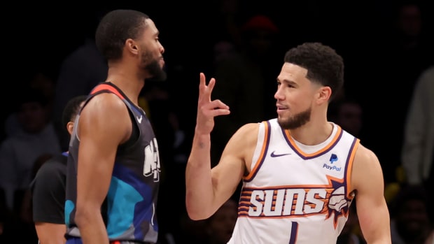 Suns guard Devin Booker flashes Nets forward Mikal Bridges’s celebration in his face.