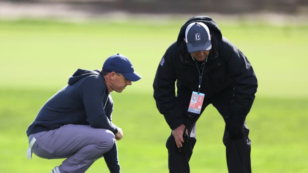 Rory McIlroy of Northern Ireland talks to rules official Stephen Cox during the first round of the AT&T Pebble Beach Pro-Am at Spyglass Hill Golf Course on February 01, 2024 in Pebble Beach, California.