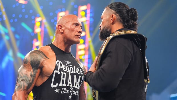 Dwayne "The Rock" Johnson and Roman Reigns stand toe-to-toe in the ring
