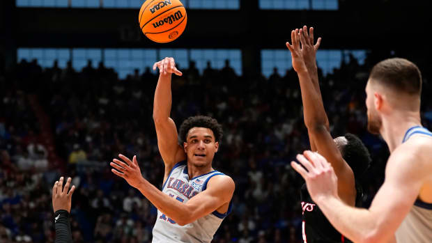 Feb 3, 2024; Lawrence, Kansas, USA; Kansas Jayhawks guard Kevin McCullar Jr. (15) passes the ball to center Hunter Dickinson (1) during the second half against the Houston Cougars at Allen Fieldhouse. Mandatory Credit: Jay Biggerstaff-USA TODAY Sports  