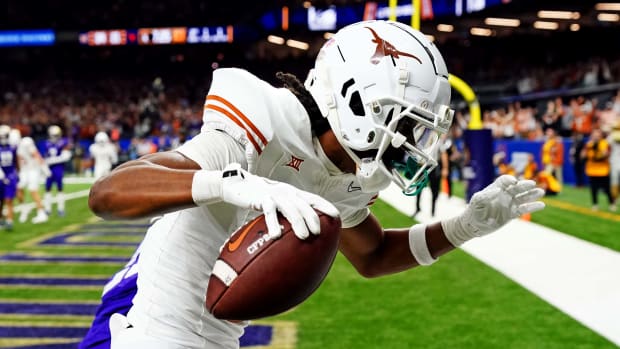 Texas Longhorns wide receiver Adonai Mitchell (5) catches a touchdown pass against Washington Huskies running back Ryder Bumgarner (25) during the fourth quarter in the 2024 Sugar Bowl college football playoff semifinal game at Caesars Superdome.