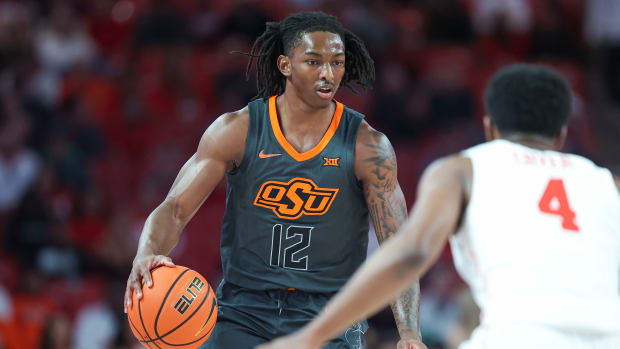 Feb 6, 2024; Houston, Texas, USA; Oklahoma State Cowboys guard Javon Small (12) controls the ball as Houston Cougars guard L.J. Cryer (4) defends during the first half at Fertitta Center. Mandatory Credit: Troy Taormina-USA TODAY Sports