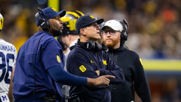 Michigan coaches Sherrone Moore, Jim Harbaugh and Jay Harbaugh during a game.