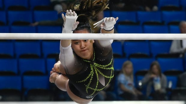 Missouri Tiger Helen Hu hangs in the air as she competes on the uneven bars during the NCAA Women s Gymnastics Los Angeles Regional at Pauley Pavilion.