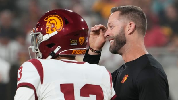 The former Arizona Cardinals head coach and now USC Trojans assistant coach Kliff Kingsbury talks to quarterback Caleb Williams (13) during the pregame warmup before playing the Arizona State Sun Devils at Mountain America Stadium in Tempe on Sept. 23, 2023.