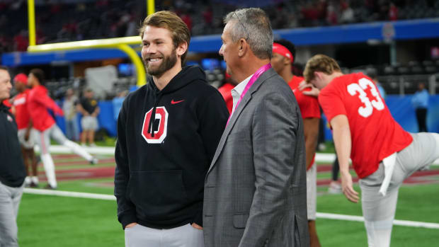 Dec 29, 2023; Arlington, Texas, USA; Ohio State Buckeyes quarterbacks coach Corey Dennis talks to his father in law, Urban Meyer, prior to the Goodyear Cotton Bowl Classic against the Missouri Tigers at AT&T Stadium.