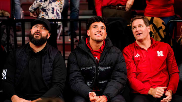 Jan 3, 2024; Lincoln, Nebraska, USA; Nebraska football assistant coach Donovan Raiola (left), his nephew Dylan Raiola (center) and athletic director Trev Alberts sit courtside before the men's basketball game against the Indiana Hoosiers at Pinnacle Bank Arena.